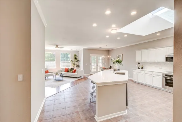 a large white kitchen with a large window