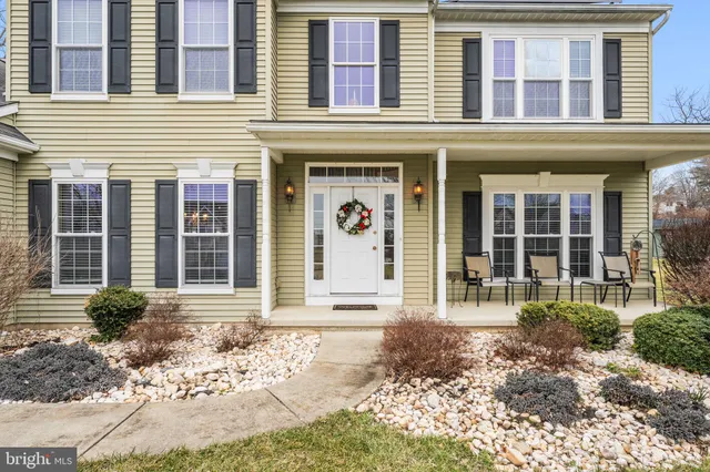 front view of a brick building with a lots of windows and plants