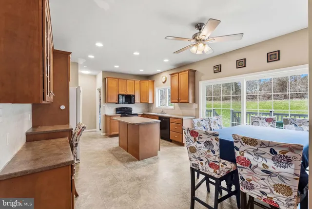 a kitchen with stainless steel appliances granite countertop a sink stove microwave and refrigerator