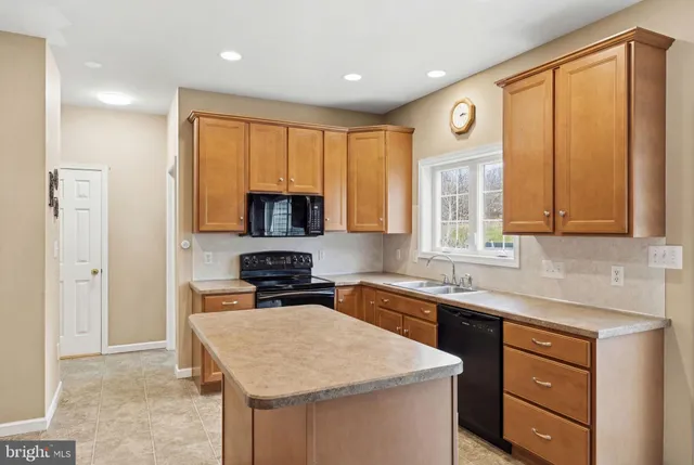a kitchen with stainless steel appliances granite countertop a sink a stove and a microwave