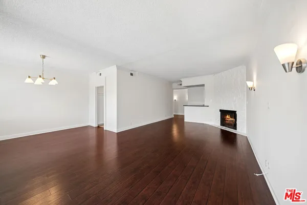 a view of a livingroom with wooden floor and staircase