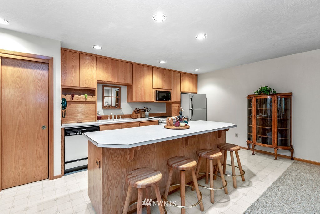 650 Frank Smith Road Toutle, WA 98649 - Photo 16 of 37 a kitchen with stainless steel appliances granite countertop table chairs sink refrigerator and cabinets
