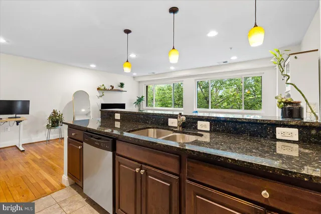 a kitchen with granite countertop a stove a sink and a refrigerator