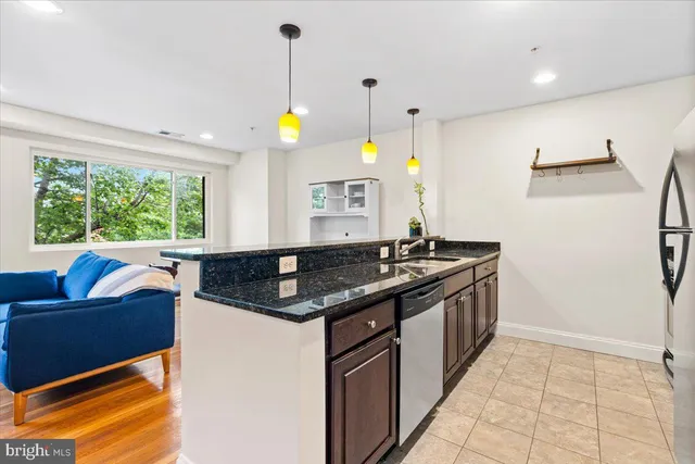 a kitchen with stainless steel appliances granite countertop a sink and a refrigerator