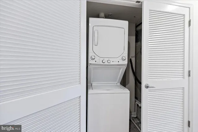 a view of a hallway with wooden floor and a bathroom
