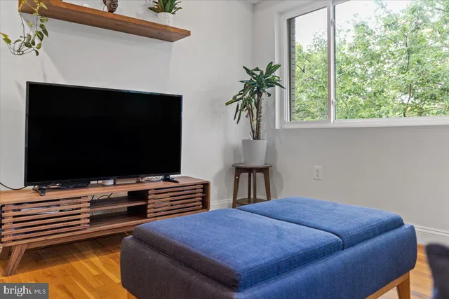 a large kitchen with stainless steel appliances a large counter top a stove and a refrigerator with wooden floor