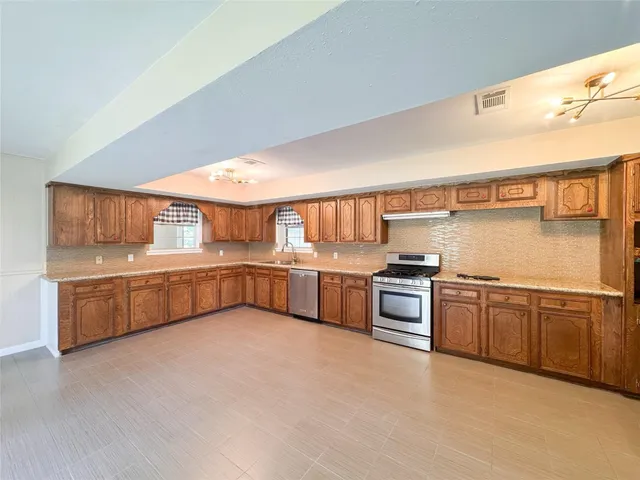 a kitchen with stainless steel appliances granite countertop a stove and a sink