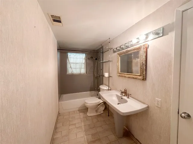 a bathroom with a sink a toilet and mirror