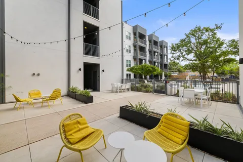 a view of a patio with couches and table and chairs and potted plants