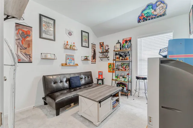 a living room with furniture and a refrigerator