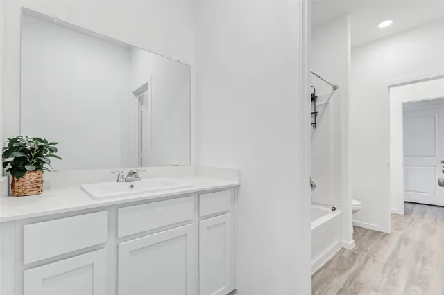 a bathroom with a double vanity sink a mirror and a bathtub