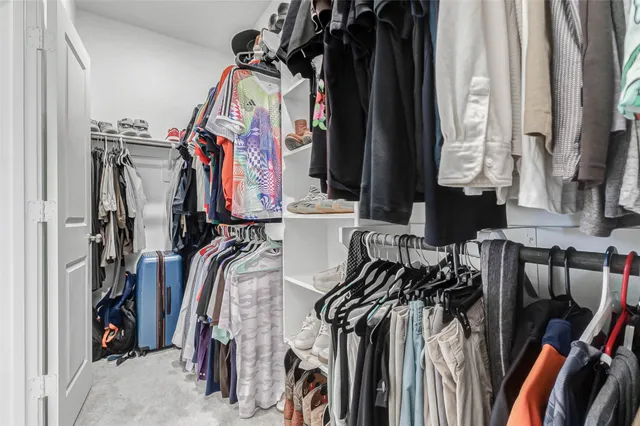 a view of walk in closet with clothes