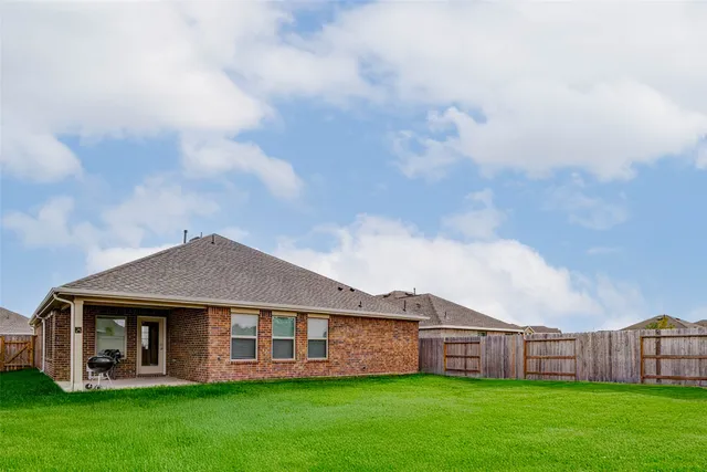 a view of a house with a big yard and large trees