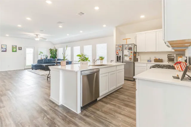 a kitchen with appliances a sink and cabinets