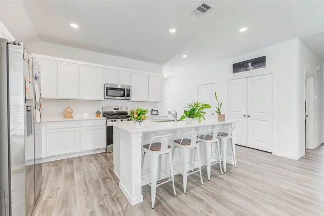 a kitchen with white cabinets and stainless steel appliances