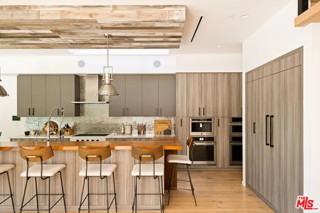 a kitchen with stainless steel appliances granite countertop a sink a stove and a wooden floors