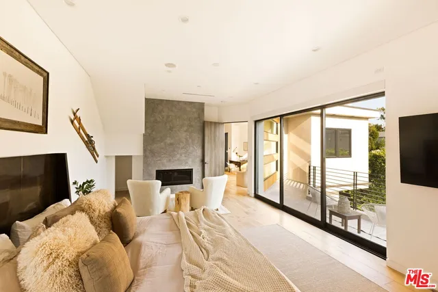 a bedroom with furniture and a large window