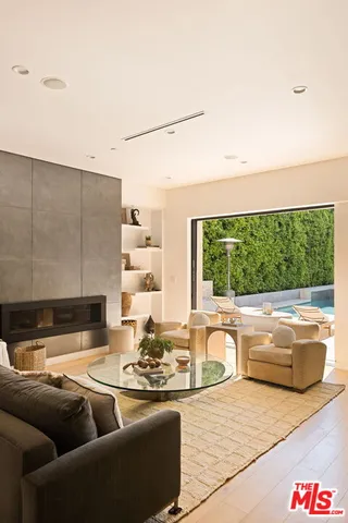 a living room with furniture a flat screen tv and a floor to ceiling window