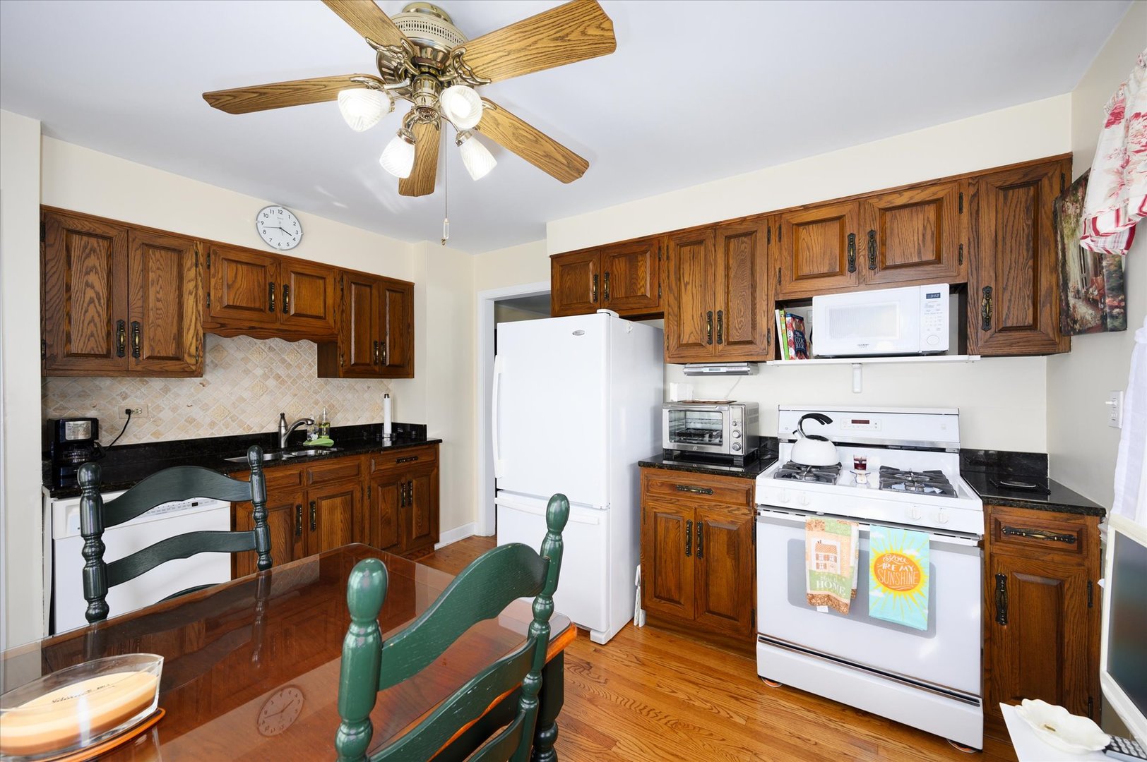 1512 Herbert Avenue Berkeley, IL 60163 - Photo 12 of 33 a kitchen with stainless steel appliances granite countertop a stove top oven a sink a dining table and chairs with wooden floor