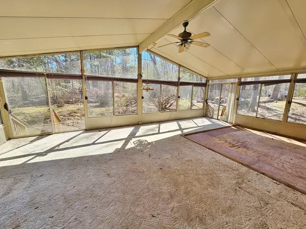 an empty room with floor to ceiling windows and walls