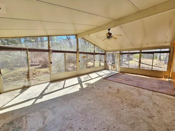 a view of a livingroom with a ceiling fan and wooden floor
