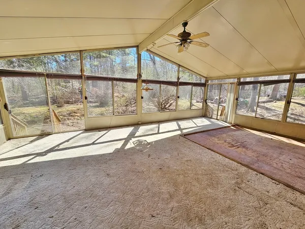 an empty room with floor to ceiling windows and walls