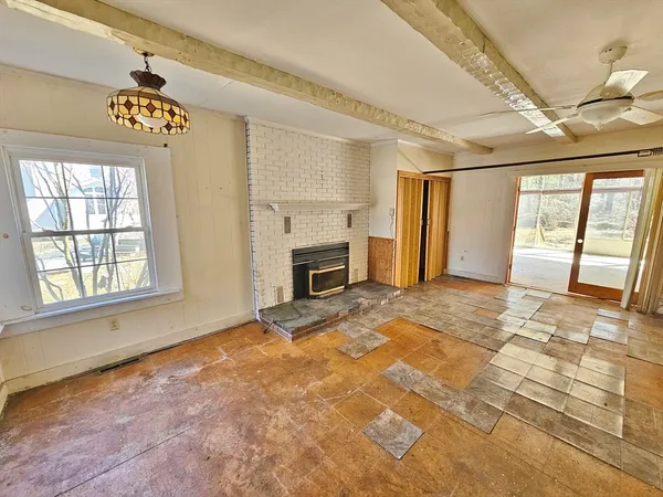 a view of an empty room with a fireplace and a window