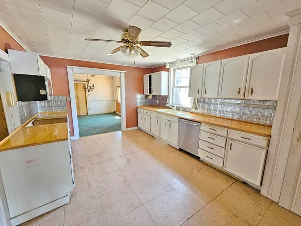 a large kitchen with a large counter top space appliances and cabinets