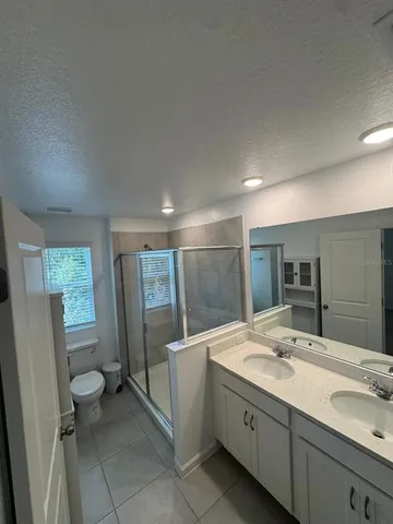 a bathroom with a granite countertop sink mirror and toilet