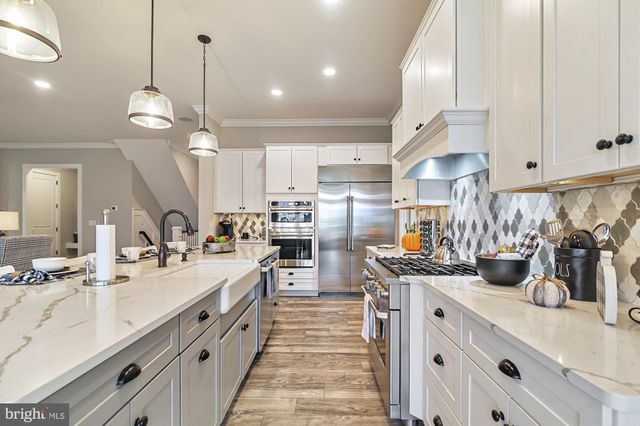 a kitchen with stainless steel appliances a sink a stove and a center island