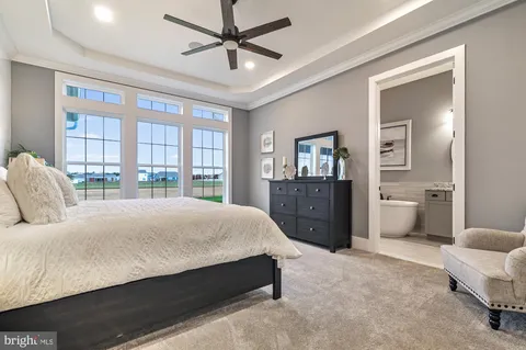 a bedroom with a large bed and a chandelier