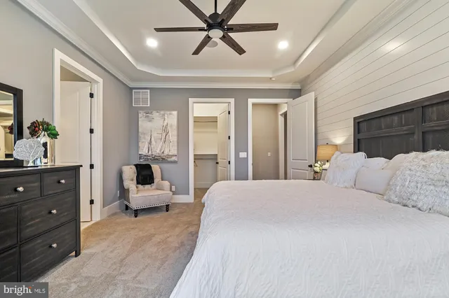 a bedroom with a large bed and ceiling fan