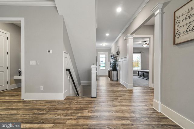 a view of a hallway with wooden floor and a living room
