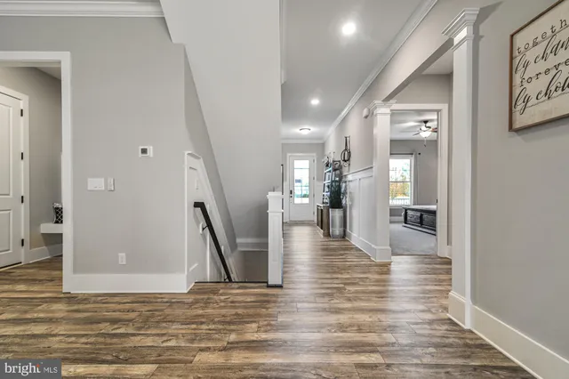 a view of a hallway with wooden floor and a living room
