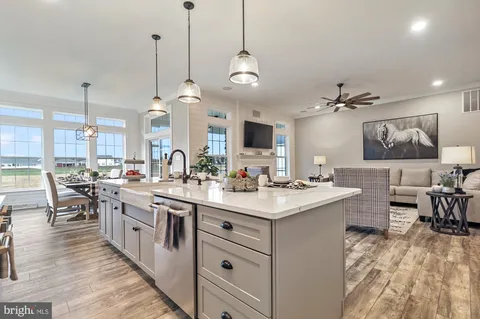 a kitchen with lots of counter space a sink appliances and living room view