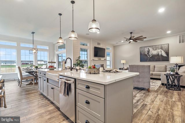 a kitchen with lots of counter space a sink appliances and living room view