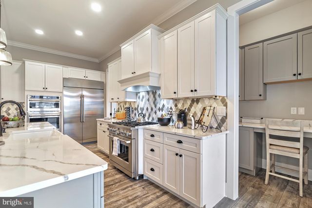 a kitchen with granite countertop a sink stove and refrigerator
