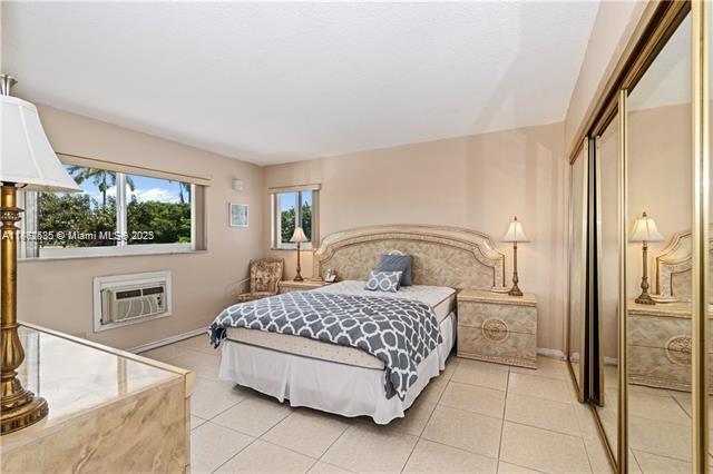 161 Northeast 10th Avenue, Unit 7C Hallandale Beach, FL 33009 - Photo 18 of 27 a bedroom with a bed and a flat screen tv