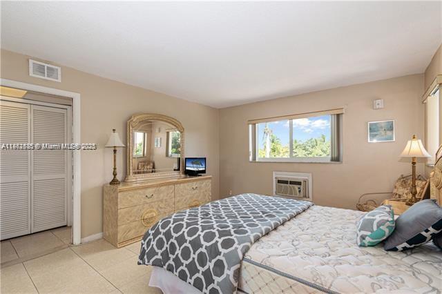 161 Northeast 10th Avenue, Unit 7C Hallandale Beach, FL 33009 - Photo 19 of 27 a bedroom with a bed and a chandelier