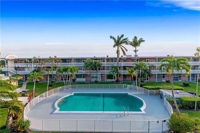 161 Northeast 10th Avenue, Unit 7C Hallandale Beach, FL 33009 - Photo 24 of 27 a swimming pool and outdoor space with lots of trees