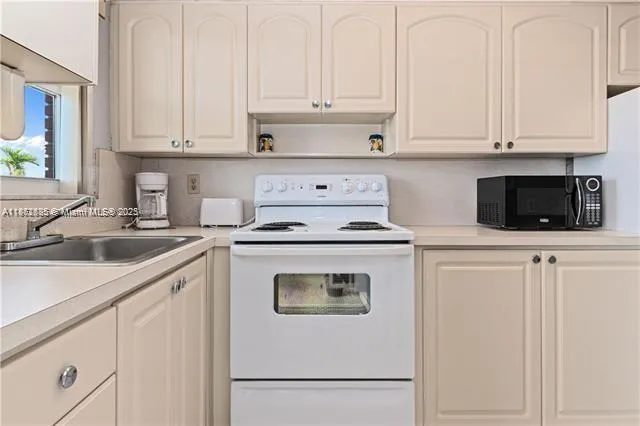 a kitchen with white cabinets and white appliances
