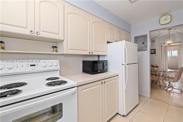 161 Northeast 10th Avenue, Unit 7C Hallandale Beach, FL 33009 - Photo 7 of 27 a white refrigerator freezer sitting inside of a kitchen