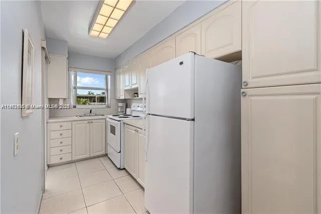 a kitchen with white cabinets and white appliances