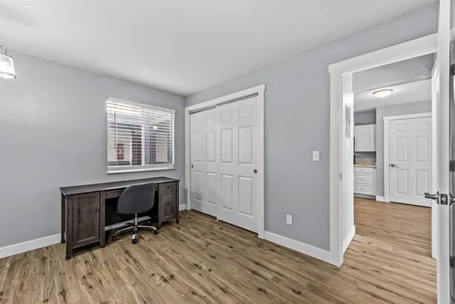 a view of a workspace with wooden floor and a window