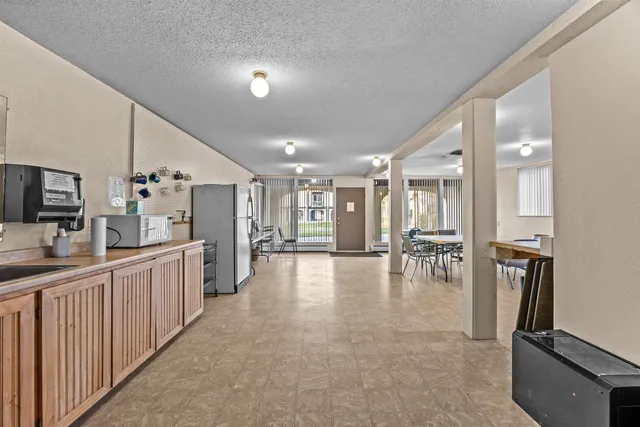 a large white kitchen with lots of counter space and stainless steel appliances