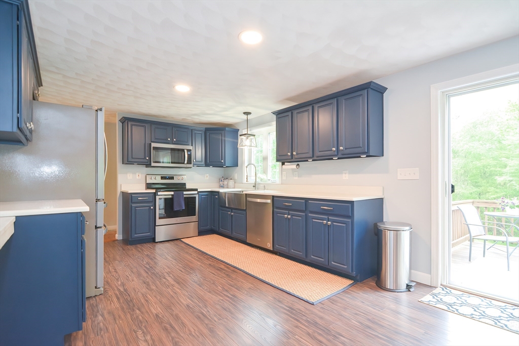 146 Gray Road Templeton, MA 01468 - Photo 2 of 37 a kitchen with stainless steel appliances wooden floors wooden cabinets a refrigerator and microwave