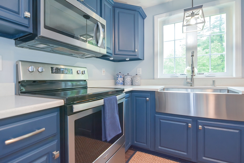 146 Gray Road Templeton, MA 01468 - Photo 3 of 37 a kitchen with stainless steel appliances granite countertop a sink a microwave cabinets and wooden floor
