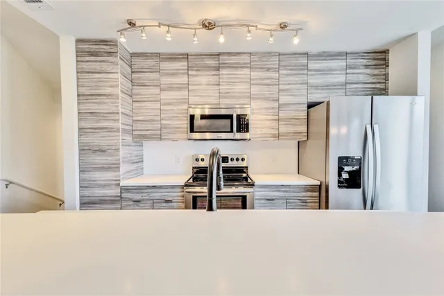 a kitchen with stainless steel appliances a refrigerator and a stove
