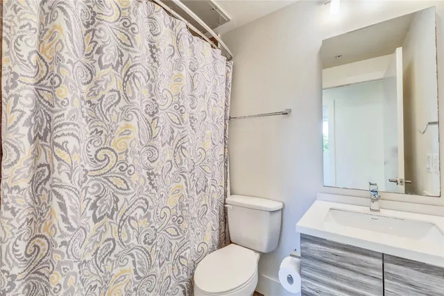 a white toilet sitting next to a bathroom sink