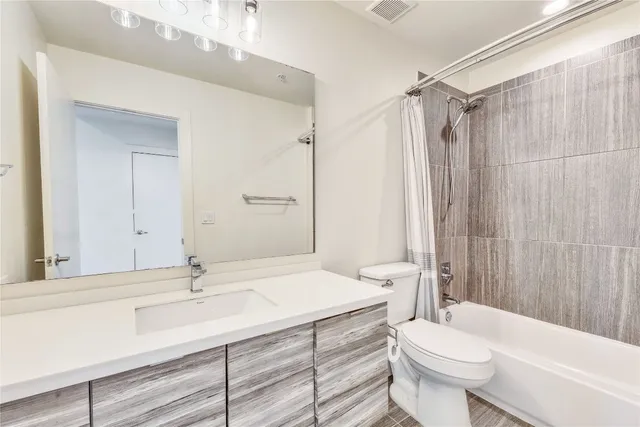 a bathroom with a tub shower and a sink